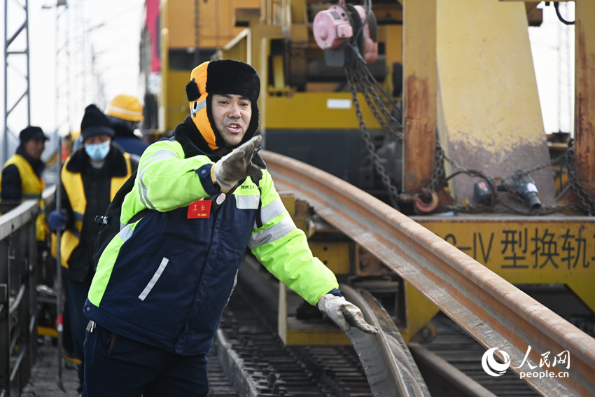 作业人员将旧钢轨按要求拨放到指定位置。人民网记者 慎志远摄