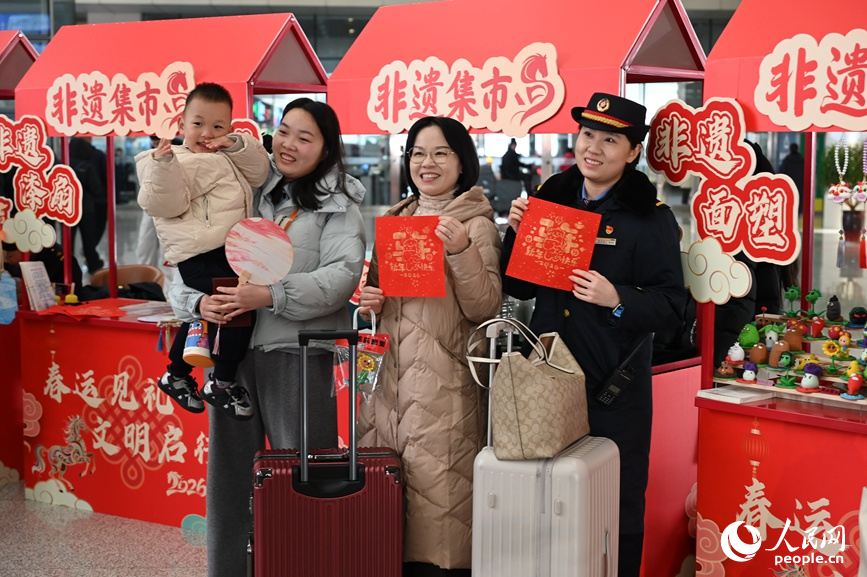 郑州东站工作人员和旅客展示非遗产品。人民网记者 王玉兴摄