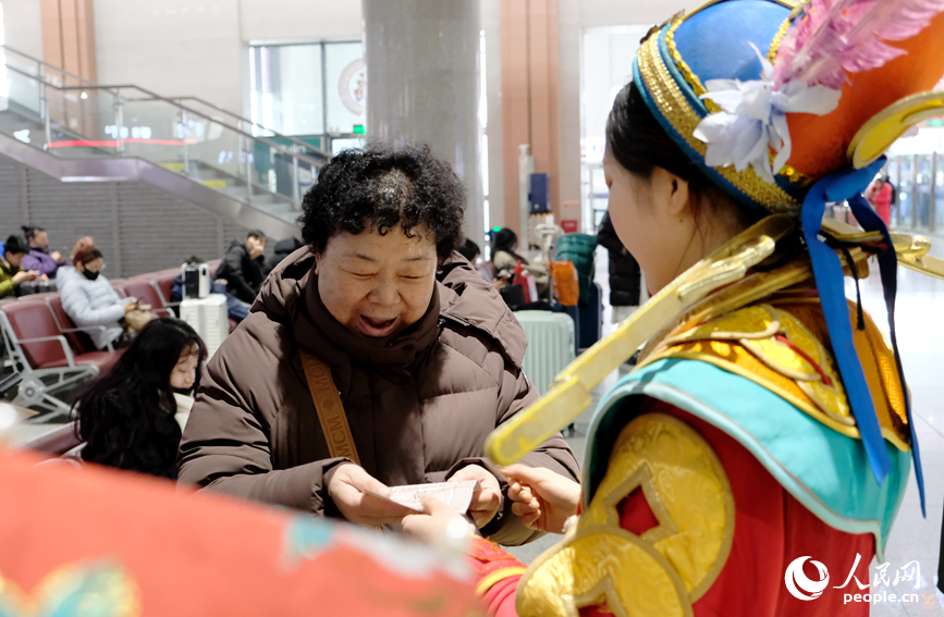 “财神”与现场旅客互动。人民网记者 常力元摄