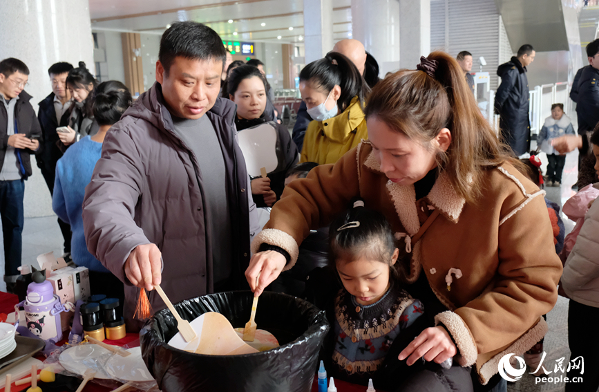 旅客在活动现场体验漆扇制作。人民网记者 常力元摄