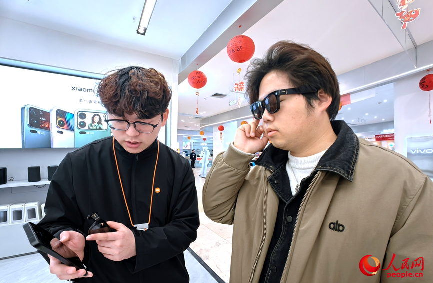 郑州一家电卖场内，顾客试戴AI眼镜。人民网记者 辛静摄