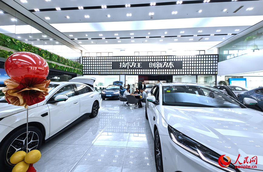 郑州一汽车4S店内，多款车型整齐陈列，消费者围坐咨询购车方案。人民网记者 宋芳鑫摄