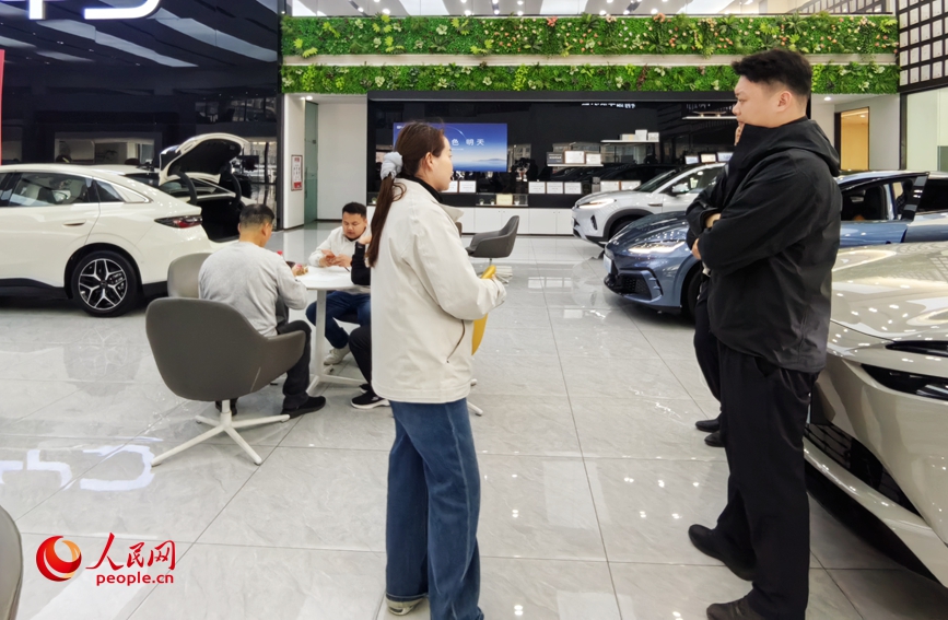 郑州比亚迪郑汴路店内，顾客在咨询购车方案。人民网记者辛静摄