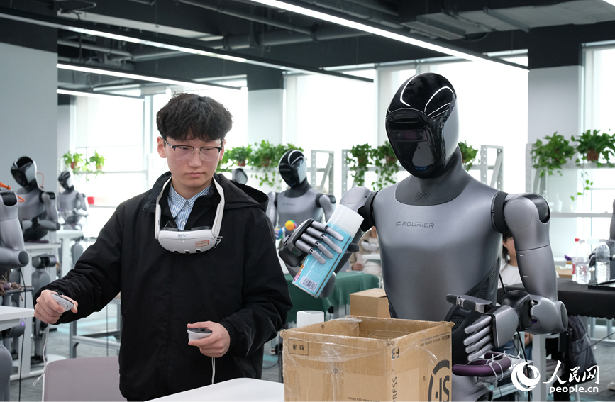 工作人员正在训练机器人拿放物品。人民网记者 常力元摄