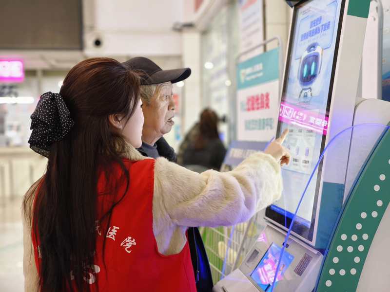 志願者協助老年患者操作自助設備。蔡昀貝攝
