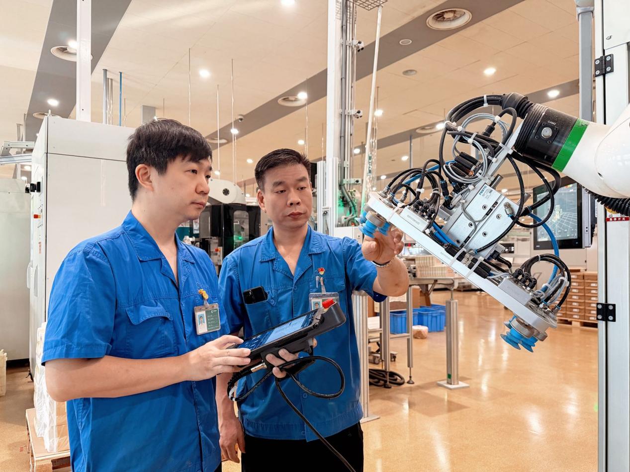 “李广锐技能大师工作室”成员正在检修封装设备。河南中烟工业有限责任公司黄金叶生产制造中心供图