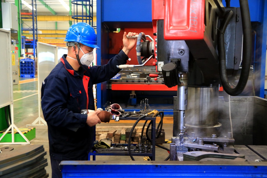 工人忙著加工汽車吊的零部件。王建棟攝
