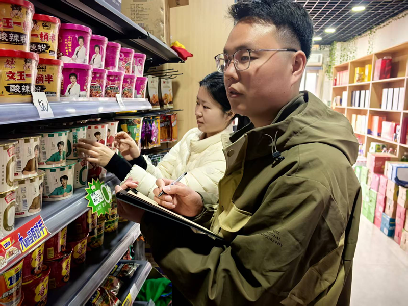 青年客戶經理在幫助店鋪開展經營分析。王輝攝