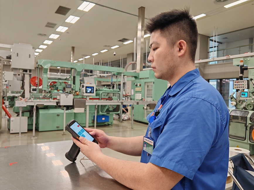 图为机台操作工使用终端“一键要料”。张亚飞摄