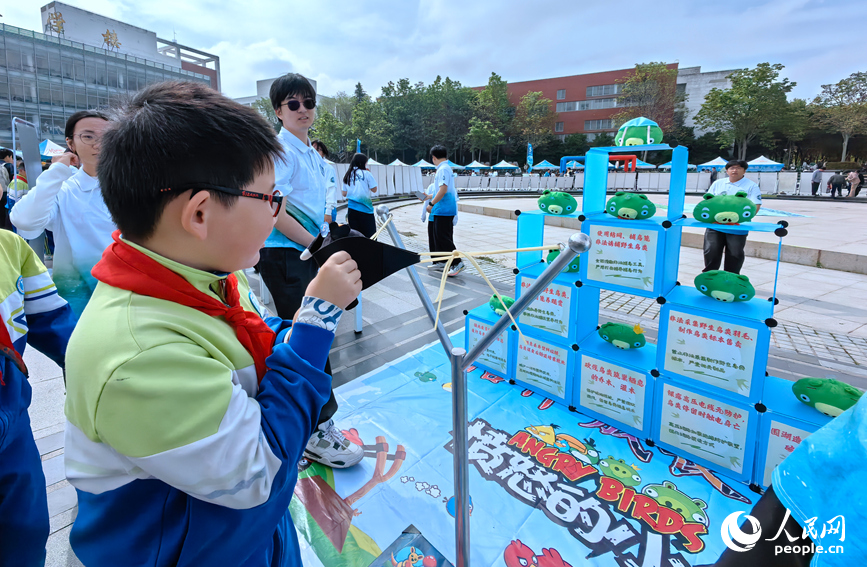 学生们在趣味互动中“解锁”保护地球小技巧。人民网记者 宋芳鑫摄