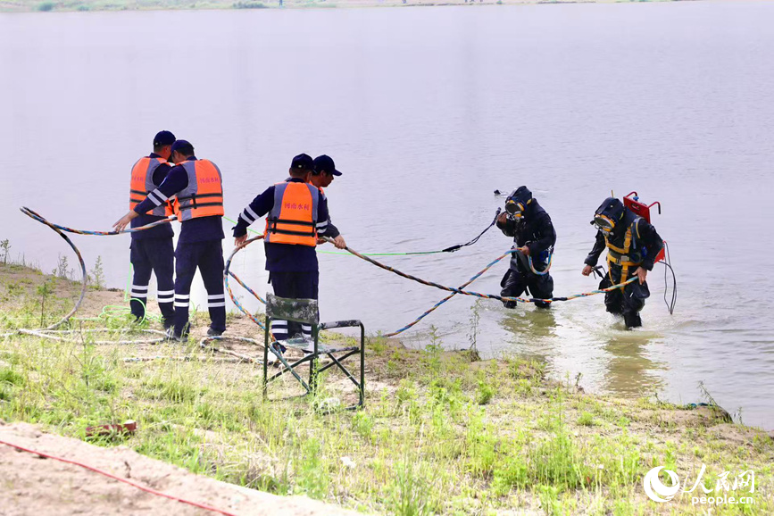 专业潜水员下水，对水库溢洪道闸门故障部位进行人工修复。人民网记者 尚明桢摄