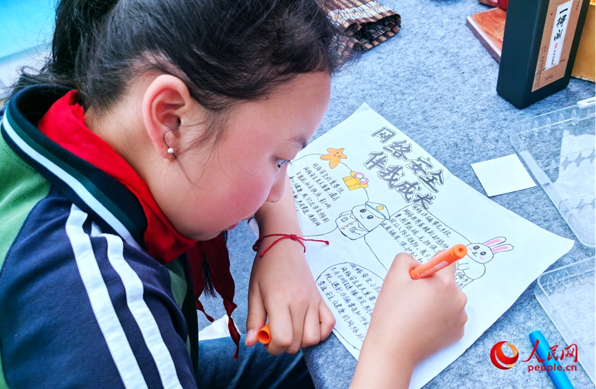 小学生在做守护网络安全的手抄报。人民网记者 王佩摄