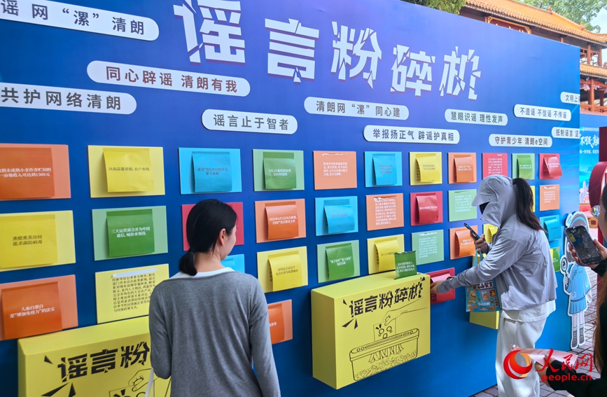 游客在景区的“谣言粉碎机”处参与互动。人民网记者 王佩摄