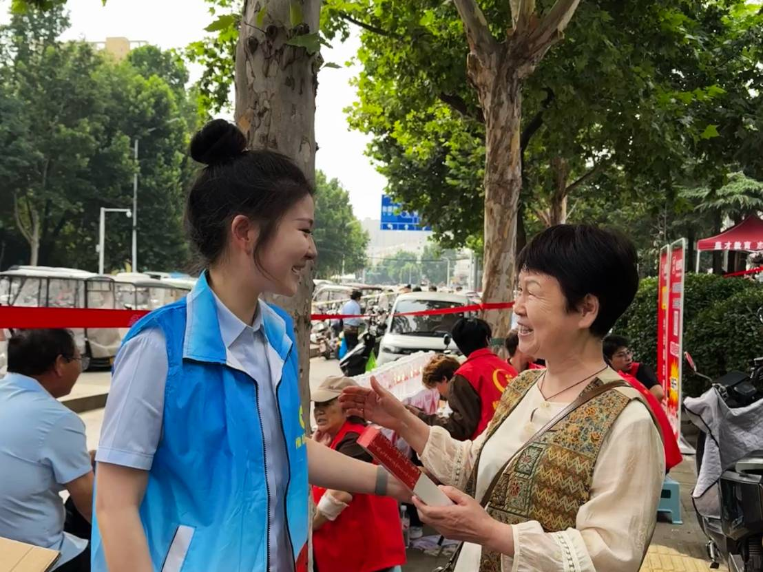 漯河临颍支行联合临颍县新城办康乐社区在临颍一高考点外设立爱心助考服务站，为考生和陪考家长提供防暑降温、便民咨询等服务，同步向陪考家长、往来行人普及金融安全与消费者权益保护知识，践行金融社会责任。胡雅欣摄