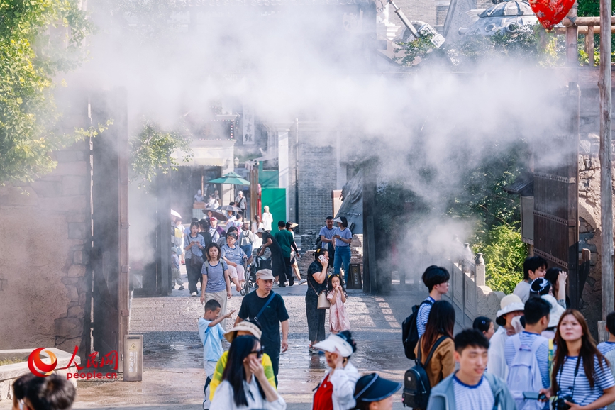 郑州电影小镇开启雾森降温装置，丝丝水雾驱散暑气。人民网记者 辛静摄