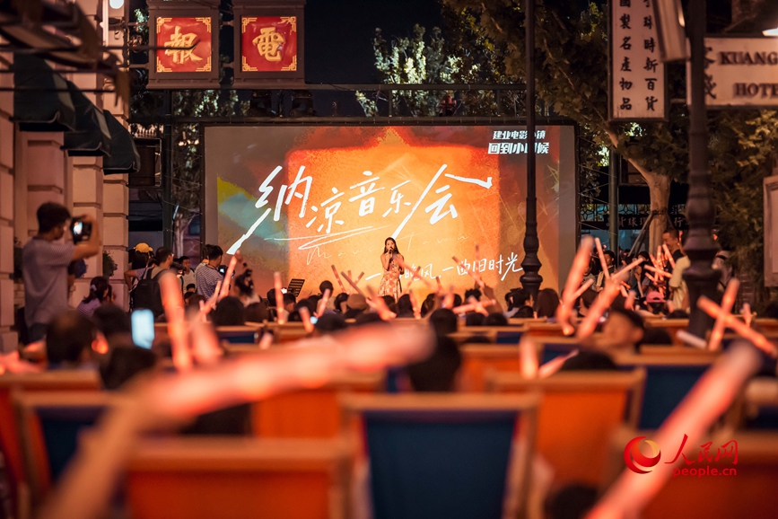 郑州电影小镇内，游客坐在躺椅上惬意听音乐会。人民网记者 辛静摄