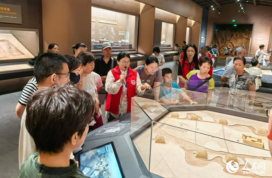 讲解员带领研学团队实地讲解大河村遗址历史。人民网记者 王佩摄
