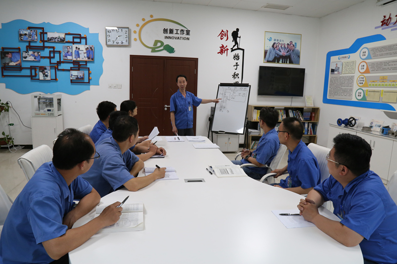 高级技师王明和向维修班介绍课题成果。王弥霄摄