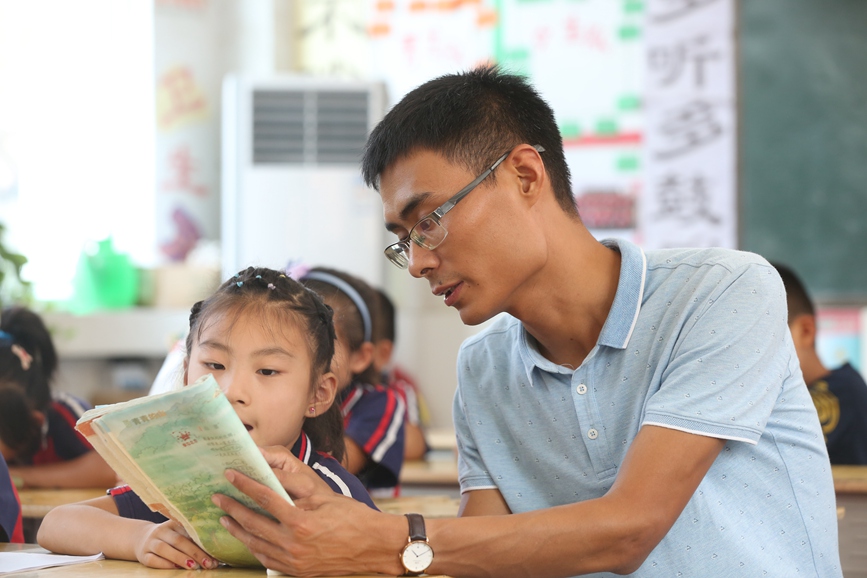 任明杰在辅导孩子读书。封丘县委宣传部供图