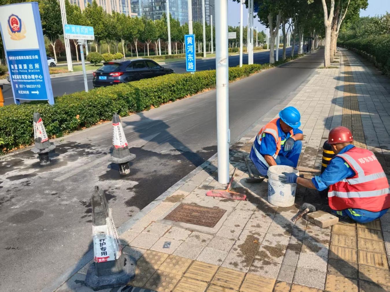 市政管养工作人员修缮黄河东路人行道板。朱浩凯摄