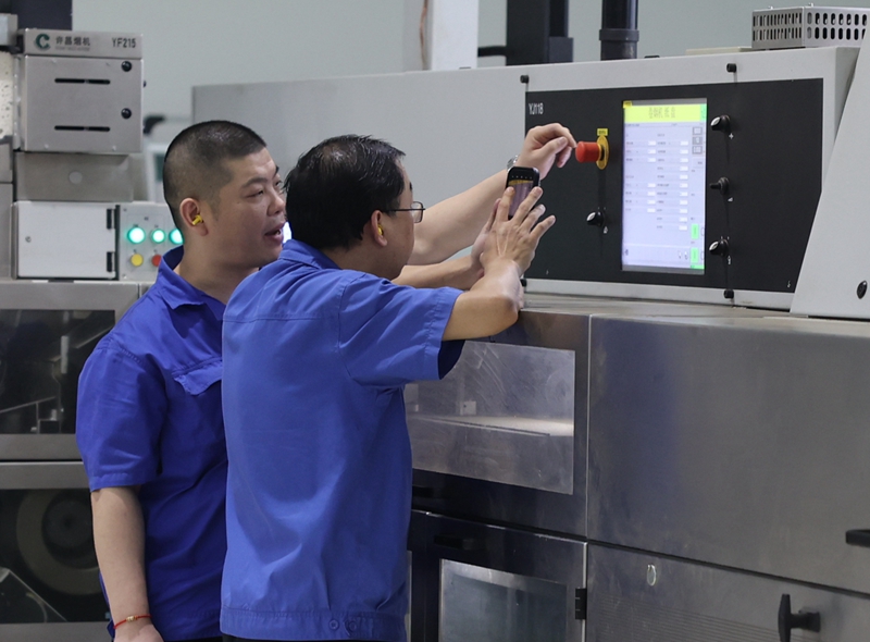 机台操作工进行设备参数优化研究。聂亮摄