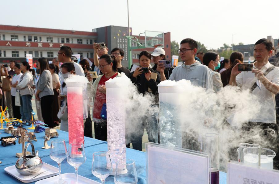與會嘉賓在妙趣實驗場·科學游樂園展區駐足體驗科學奧秘並拍照。翟登雲攝