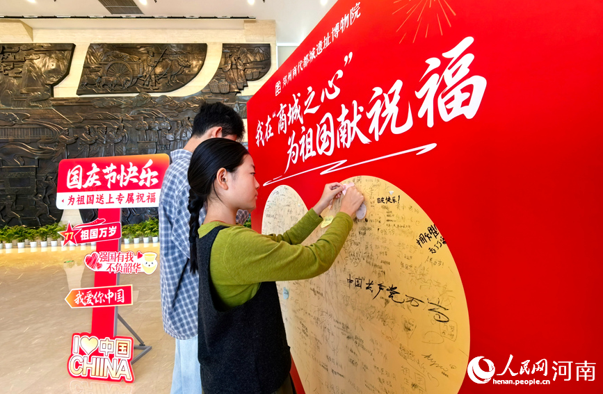 国庆假期，游客打卡郑州商都遗址博物院，在表白墙上写下对祖国的祝福。人民网记者 宋芳鑫摄