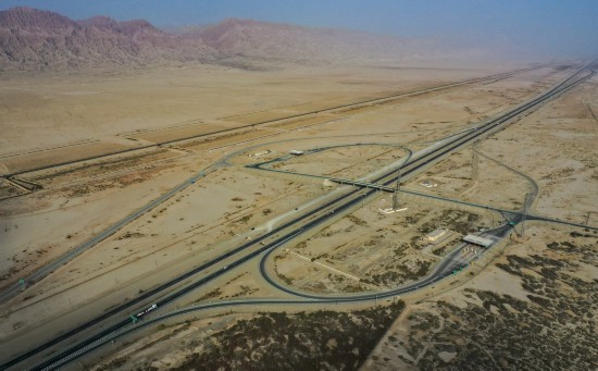 车辆行驶在新疆吐（鲁番）和（田）高速公路库尔勒至阿克苏段的路面上（2020年10月15日摄，无人机照片）。新华社记者 胡虎虎 摄
