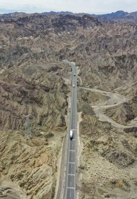 车辆行驶在贯穿新疆托克逊县干沟的山区高速公路上（2021年7月19日摄，无人机照片）。新华社记者 胡虎虎 摄