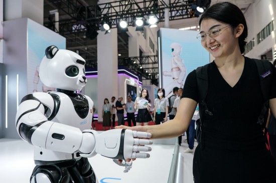  一名女士在2023世界机器人大会现场与智能机器人握手（2023年8月16日摄）。当日，2023世界机器人大会在北京开幕。新华社记者 彭子洋 摄
