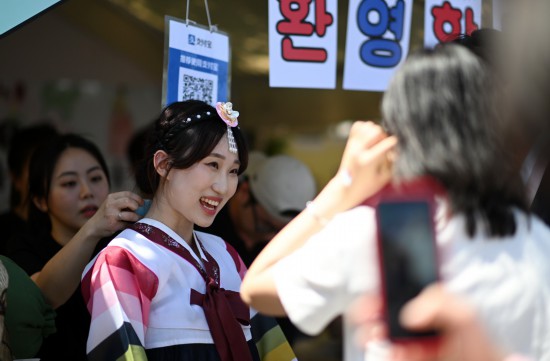 5月12日，在天津大学国际文化节，一名韩国留学生在展位前和观众交流。