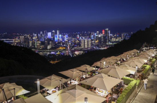 8月23日，重庆南岸区南山风景区内一家网红火锅店内，游客们一边品尝火锅，一边欣赏重庆迷人的夜景。新华社记者 刘潺 摄