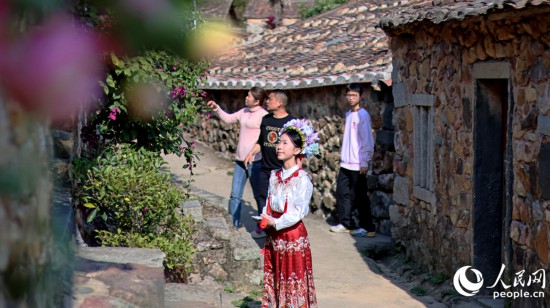 簪花少女与古民居相映成趣。人民网 李昌乾摄