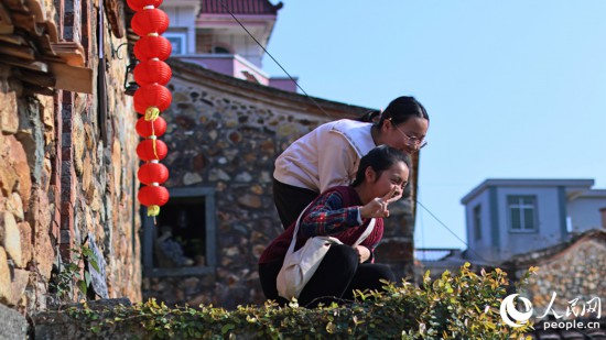 小朋友在墙头与摄影师互动。人民网 李昌乾摄